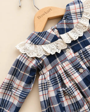 Navy blue plaid girls' frock with eyelet lace collar, long sleeves, buttons, and front pockets