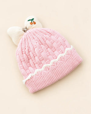 Knitted baby beanie with bow detail, cherry embroidery, and scalloped trim