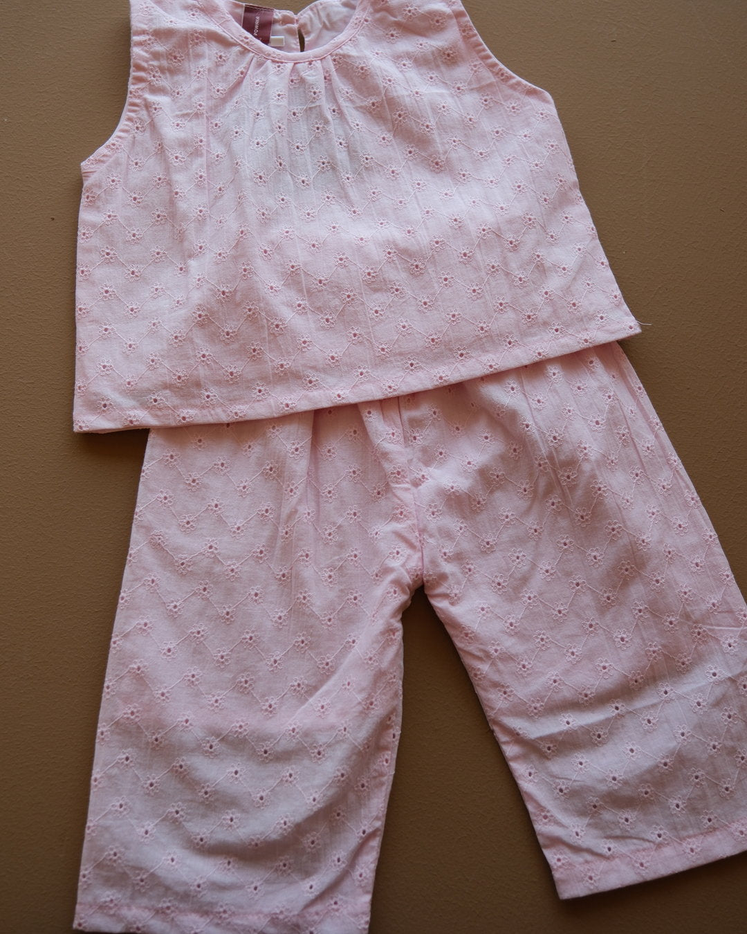 Soft pink sleeveless floral eyelet jumpsuit with wide-leg pants