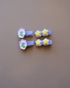 Assorted colorful decorative hair clips with bows, flowers, and playful motifs