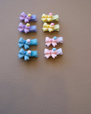 Assorted colorful decorative hair clips with bows, flowers, and playful motifs