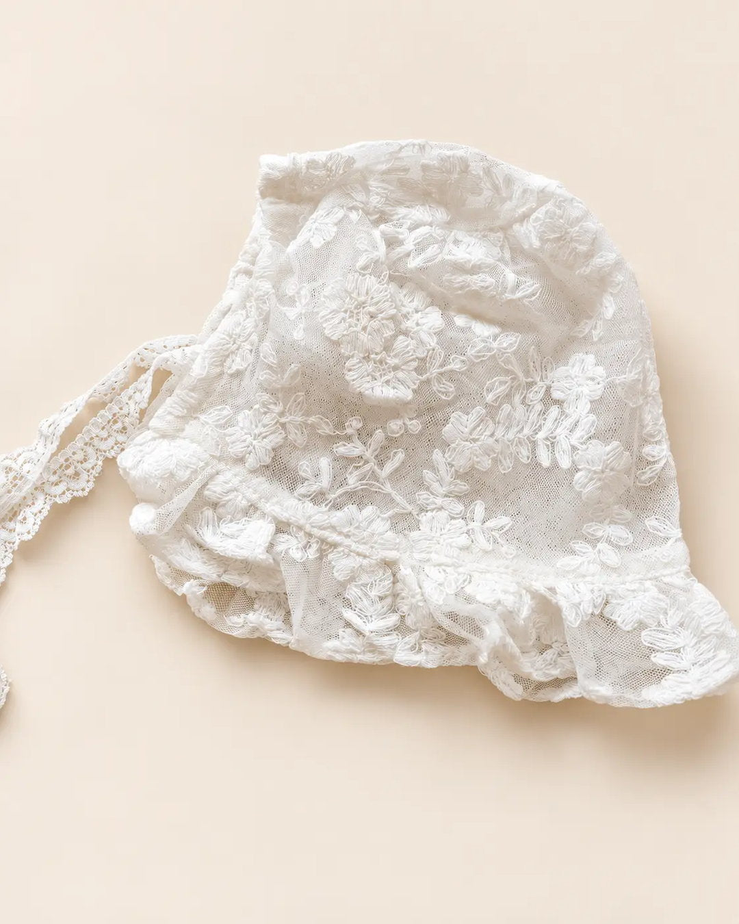 Delicate floral lace baby bonnet with tie straps