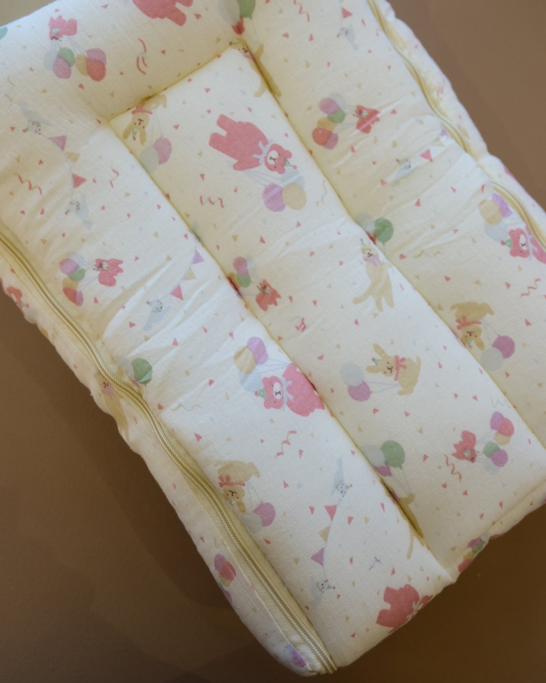 Ivory padded newborn sleeping bag with pink and green floral print
