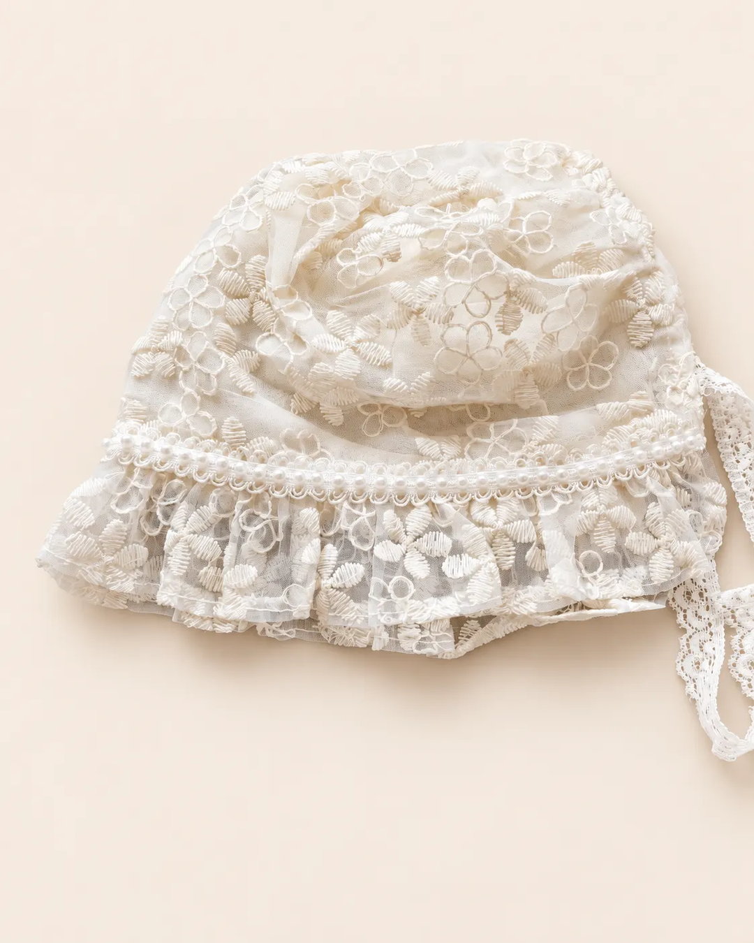 Delicate floral lace baby bonnet with tie straps