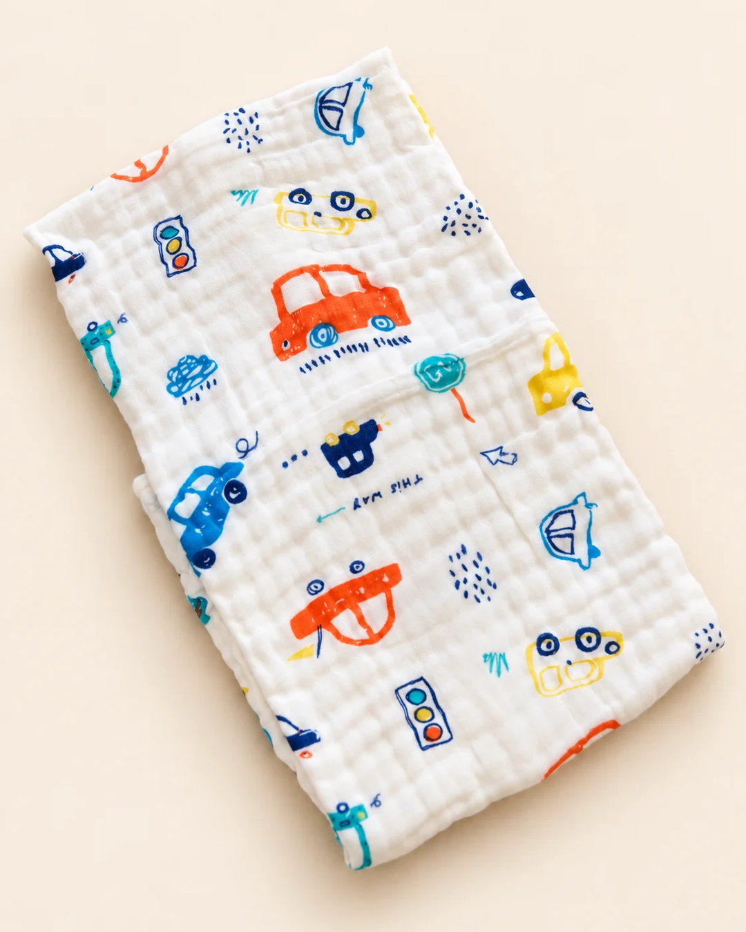 Printed muslin baby towel with playful elephant, unicorn, vehicle, and multicolor designs