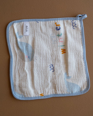 Assorted printed baby washcloths with colorful animal, floral, rainbow, and playful designs