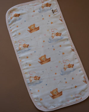 Printed off-white baby burp cloth with playful animal motifs and rounded edges