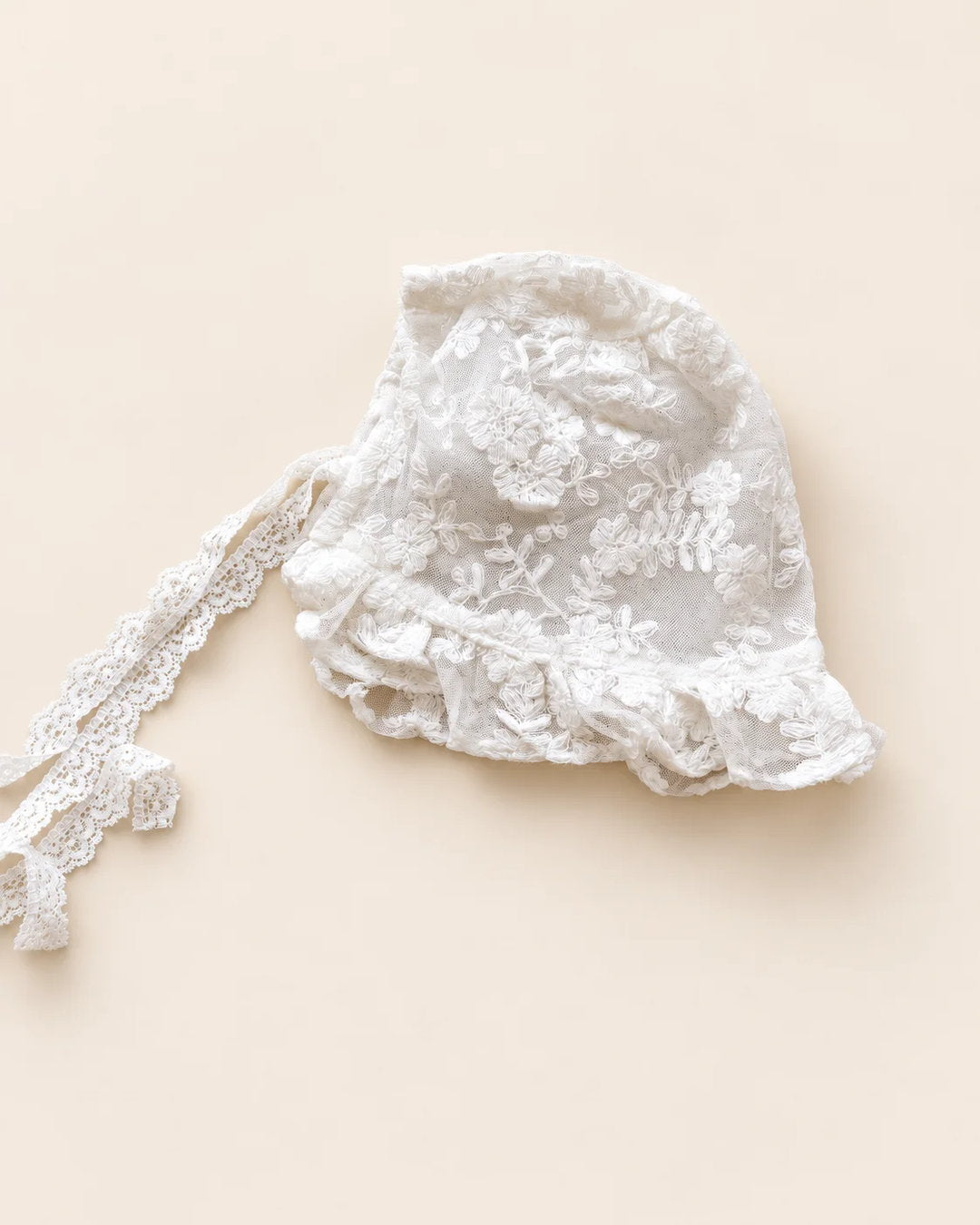 Delicate floral lace baby bonnet with tie straps