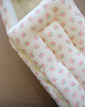Off-white newborn swaddle sleeping bag with pink and green floral print