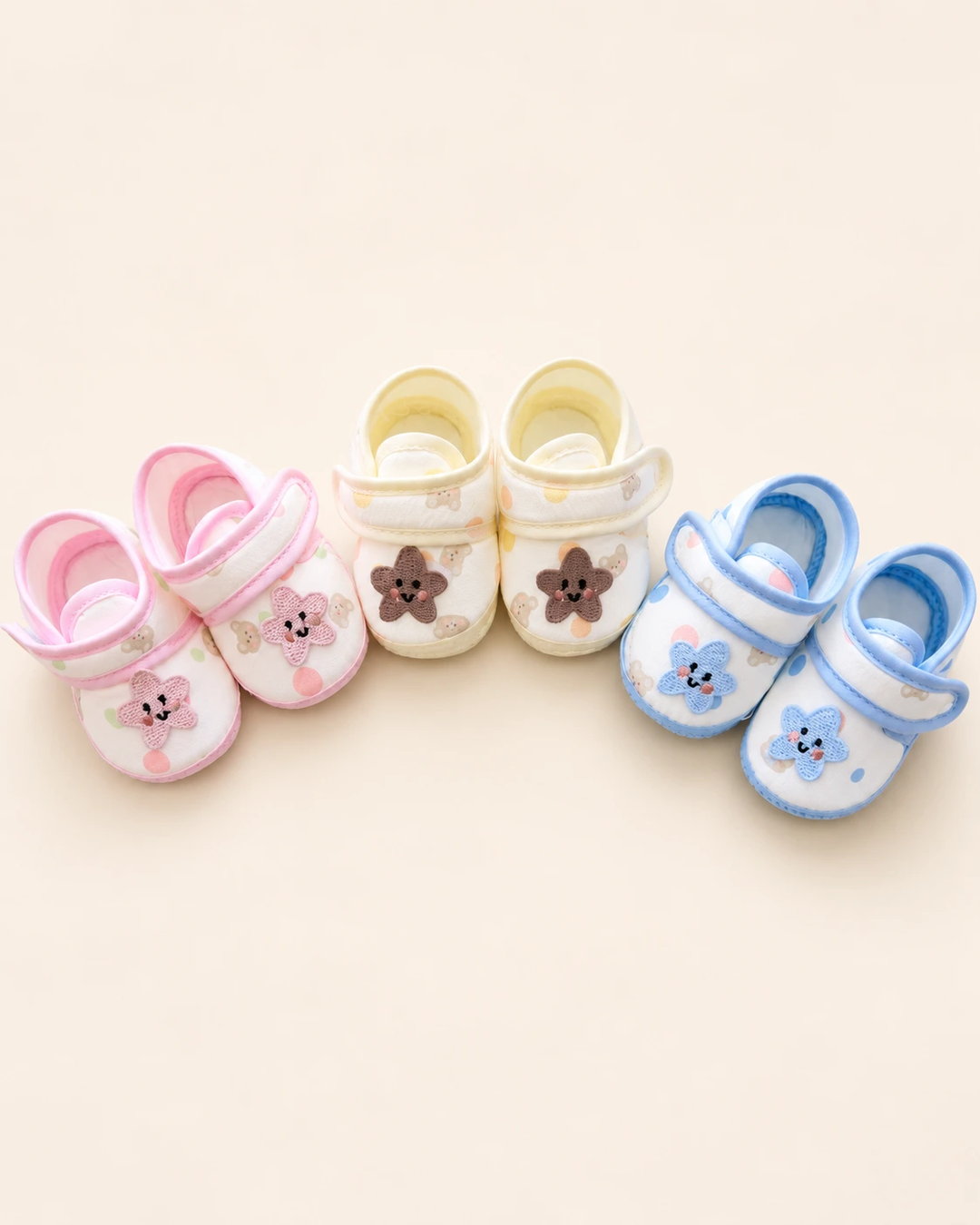 Baby booties with star applique, bear print, and pastel trim