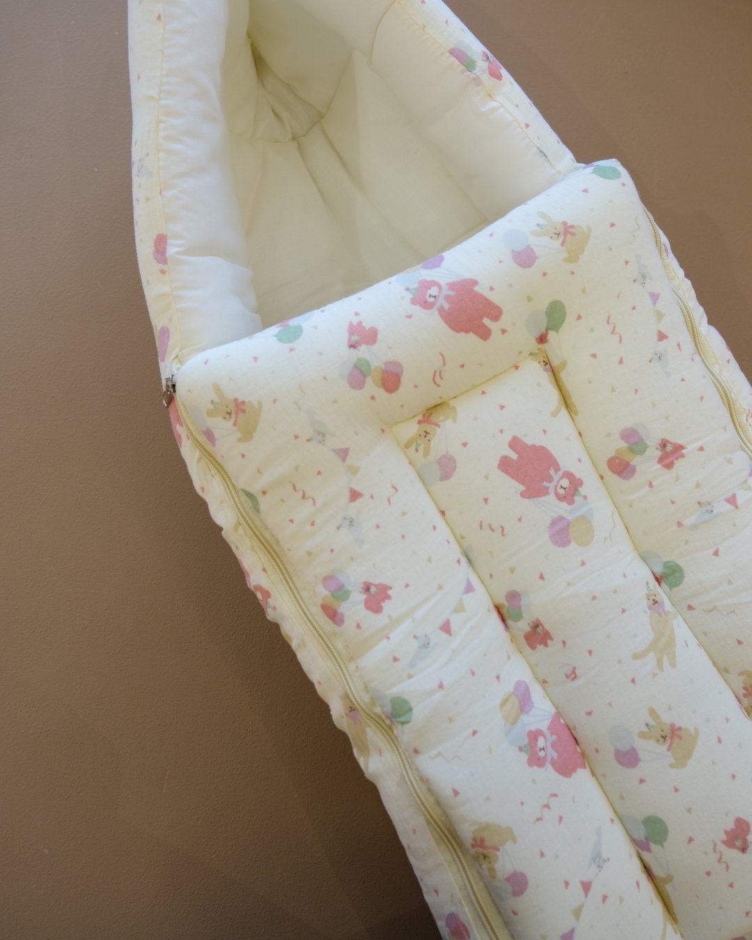Ivory padded newborn sleeping bag with pink and green floral print