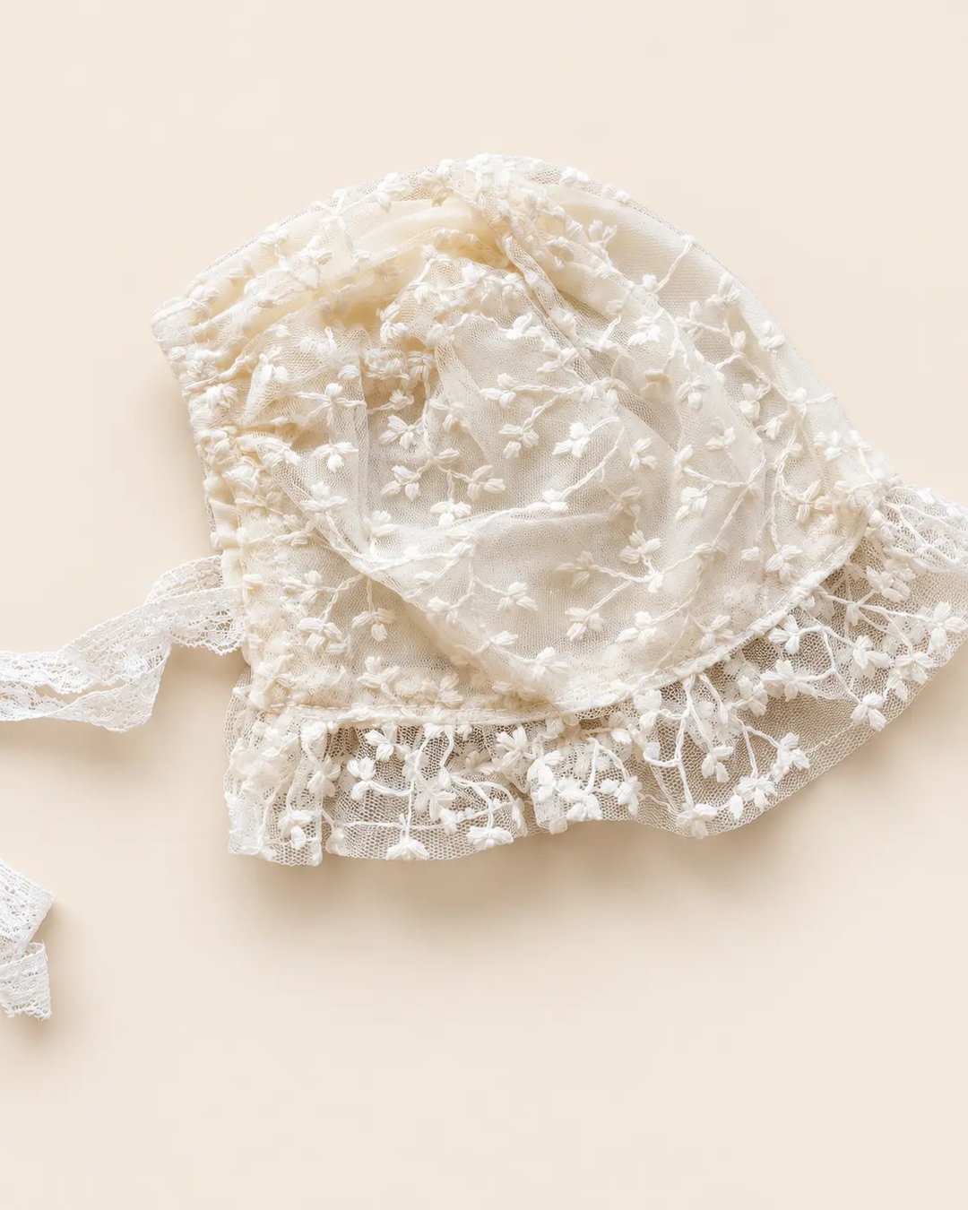 Delicate floral lace baby bonnet with tie straps