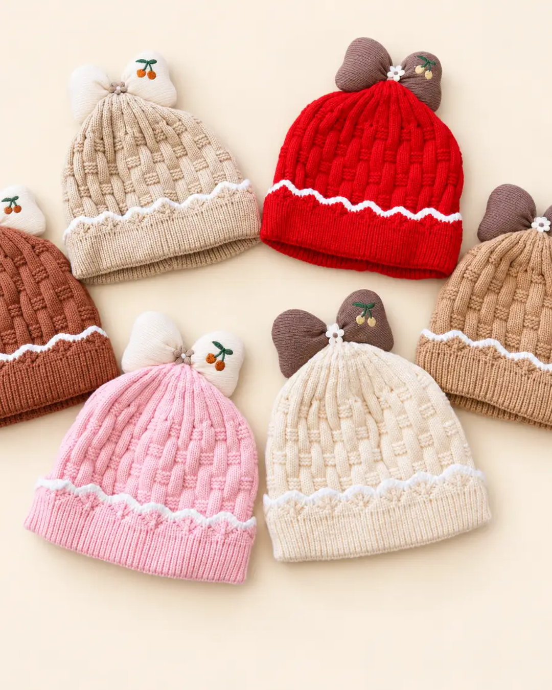 Knitted baby beanie with bow detail, cherry embroidery, and scalloped trim