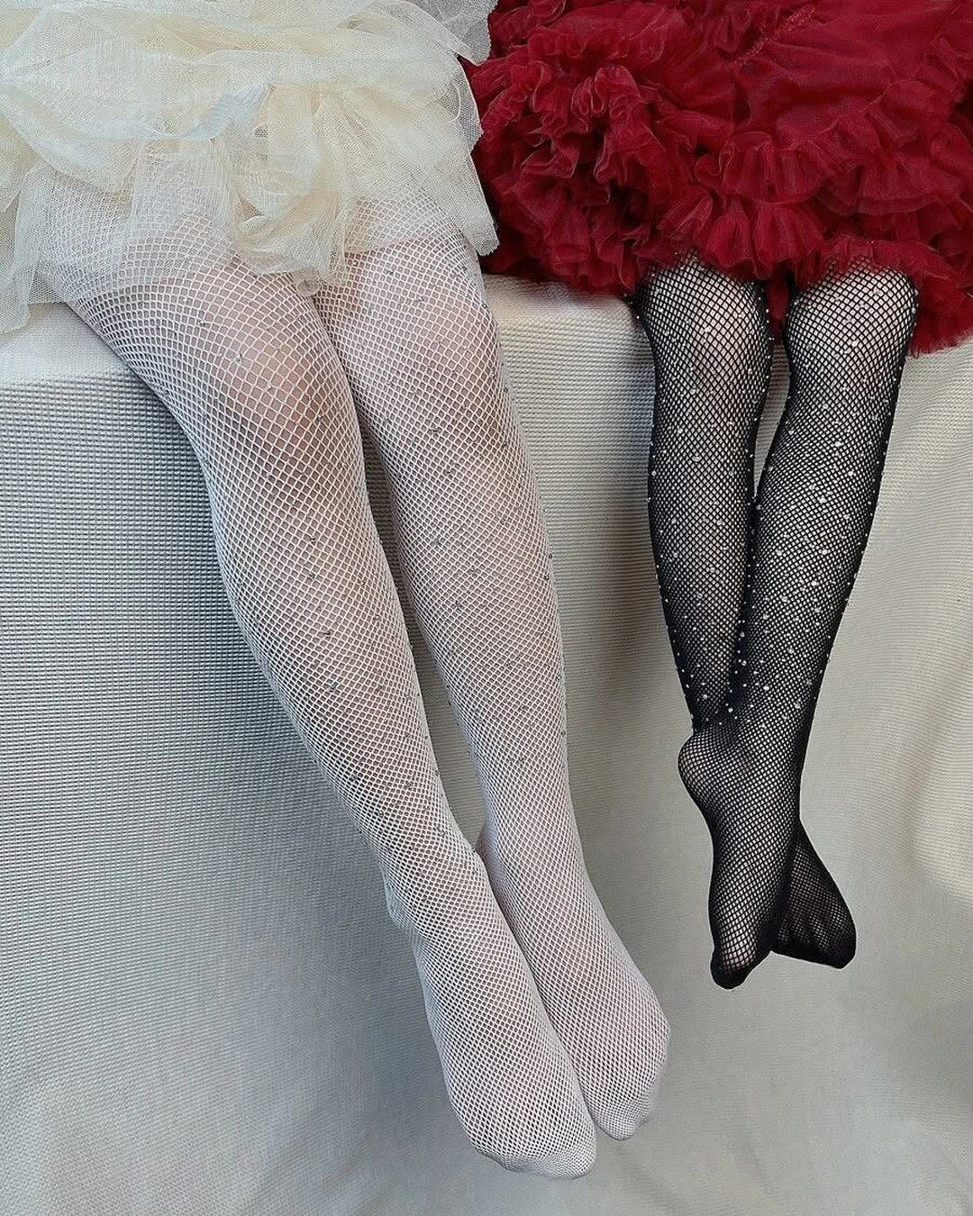 White and black fishnet stockings displayed with party dresses