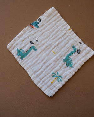 Printed off-white baby burp cloth with playful animal motifs and rounded edges