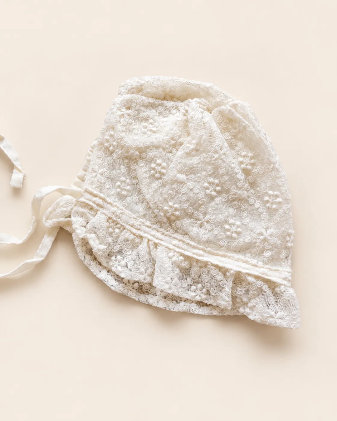 Delicate floral lace baby bonnet with tie straps