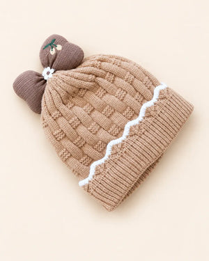 Knitted baby beanie with bow detail, cherry embroidery, and scalloped trim