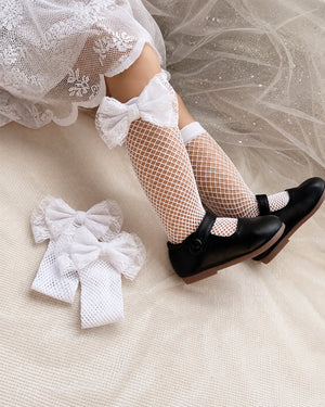 Children's fishnet stockings with oversized lace bows in black and white