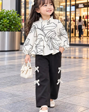 Child wearing a printed long-sleeve bow cord set with coordinating pants