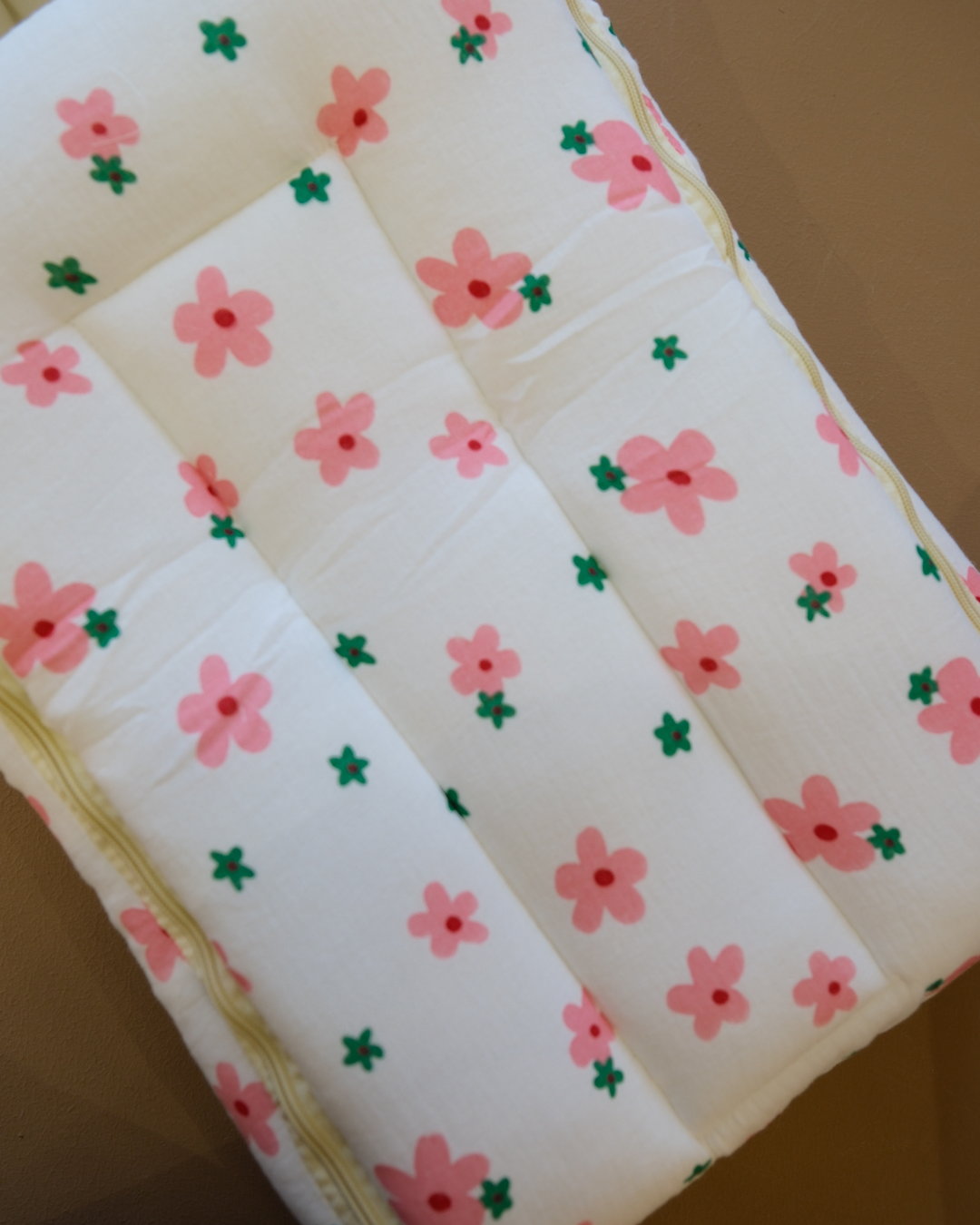 Ivory padded newborn sleeping bag with pink and green floral print