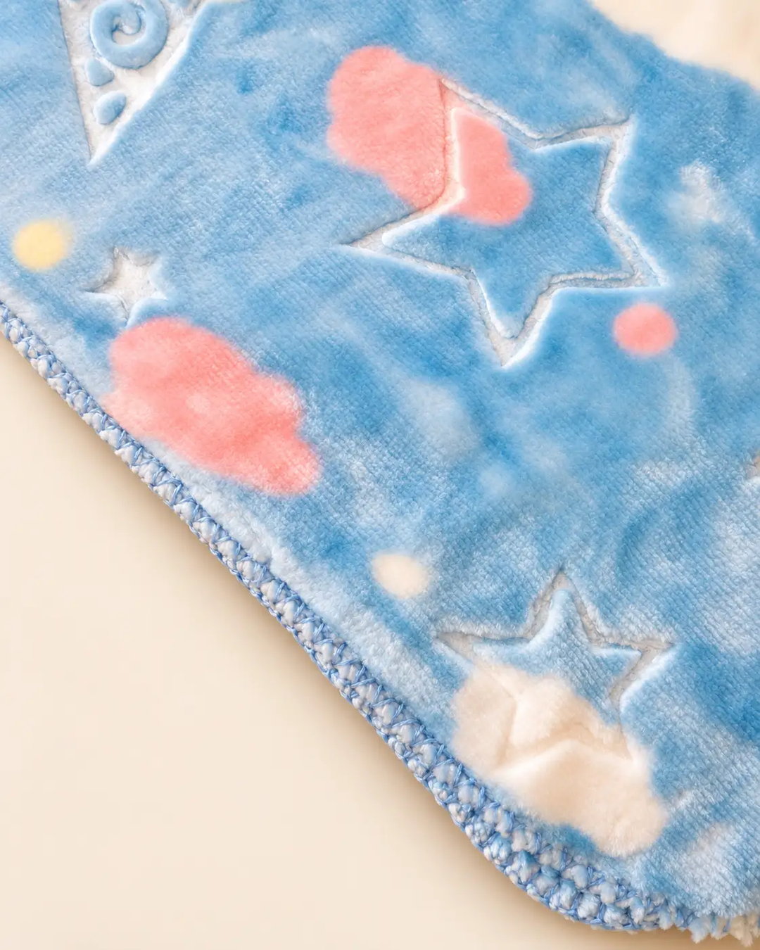 Blue and pink baby blanket with star, moon and cloud patterns