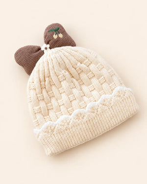 Knitted baby beanie with bow detail, cherry embroidery, and scalloped trim