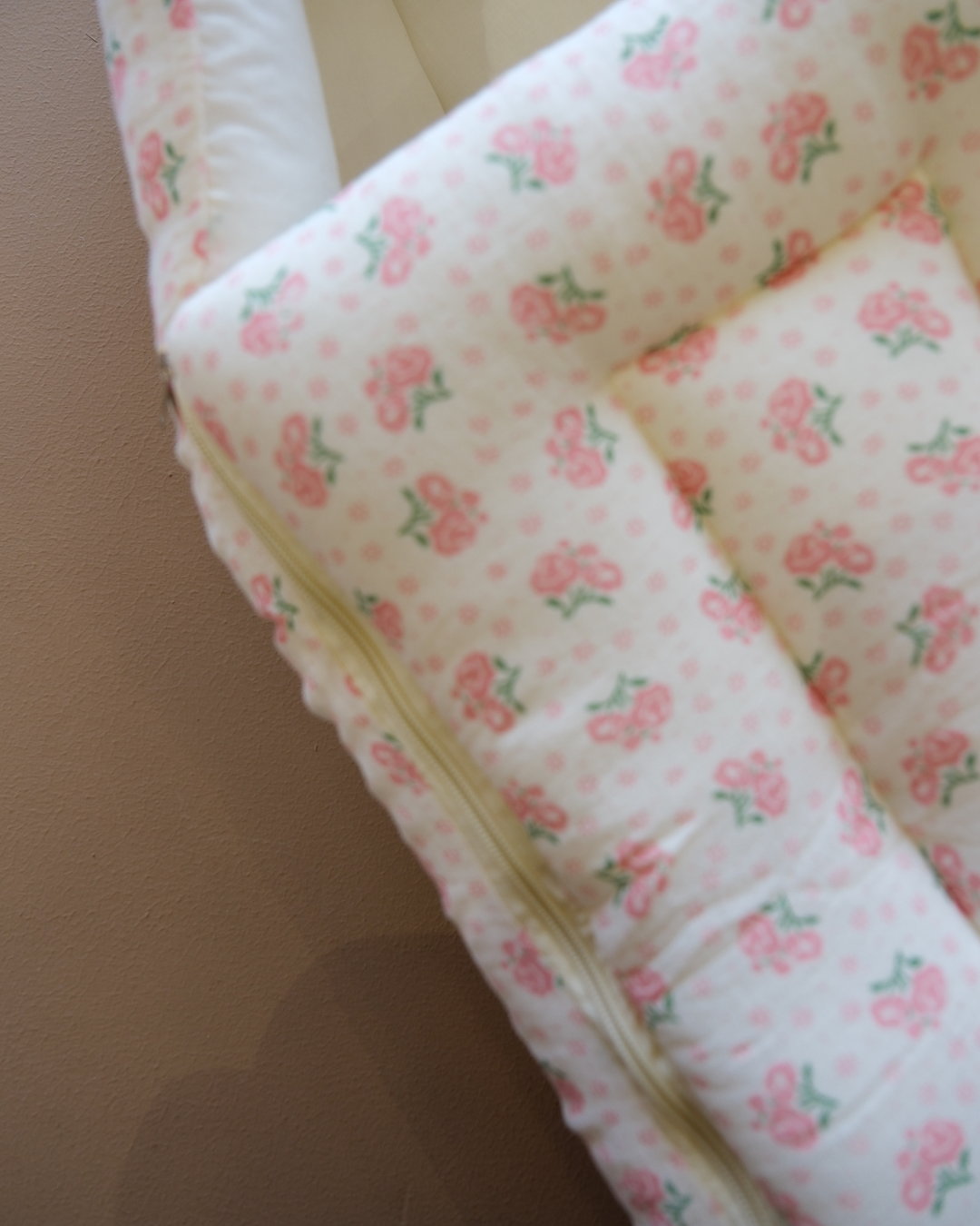 Off-white newborn swaddle sleeping bag with pink and green floral print