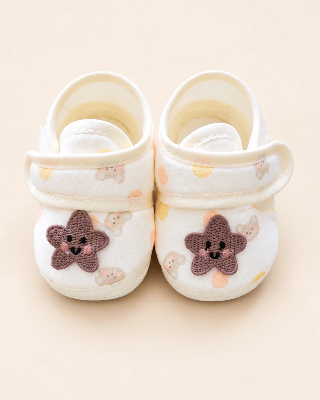 Baby booties with star applique, bear print, and pastel trim
